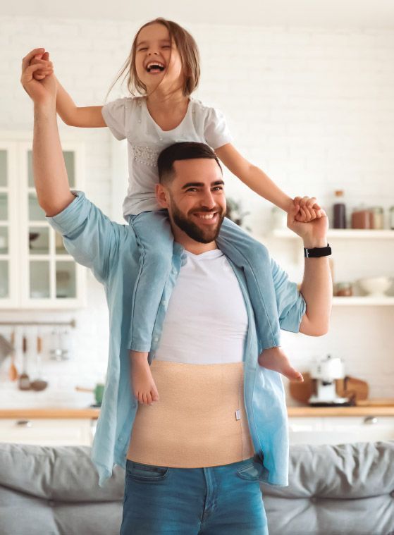 Hombre con faja tubular jugando con su hija | PrimSpine Move